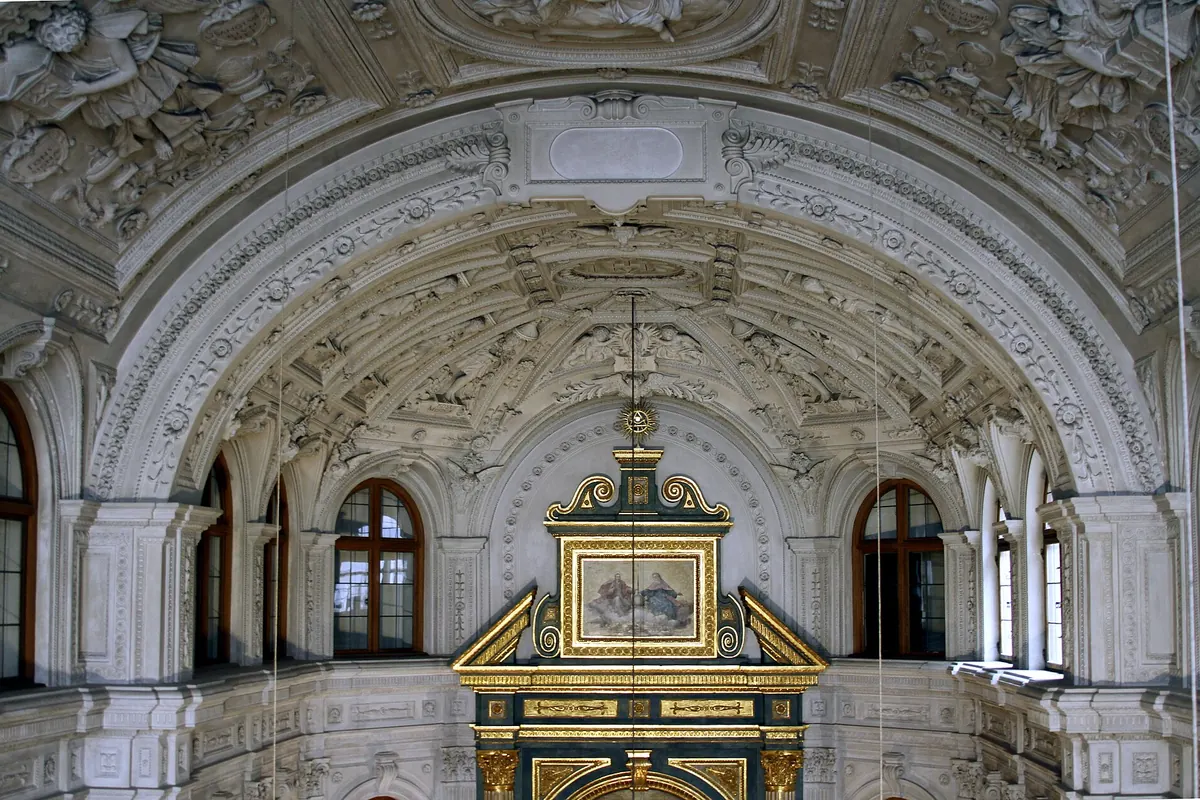 The triumphal arch of the chapel above the altar, framed in white stucco relief with windows on either side.