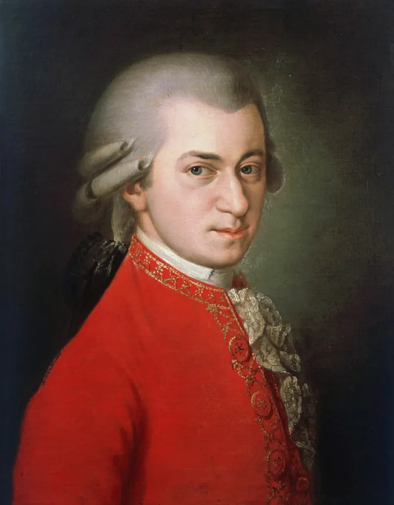 A portrait of Wolfgang Amadeus Mozart in a red coat holding a sheet of music